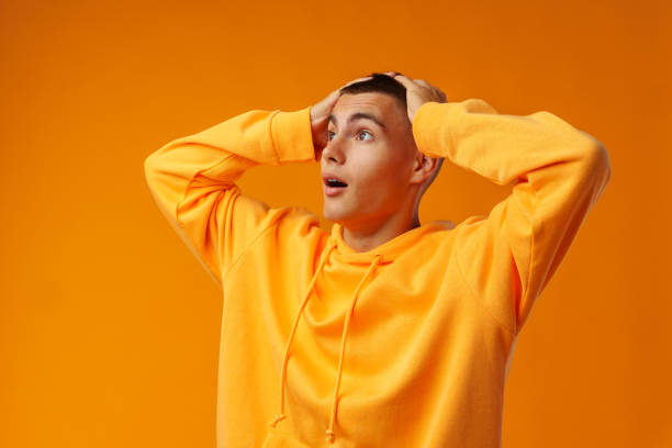 istock Young handsome man shocked with surprise expression standing over yellow background 1440448489