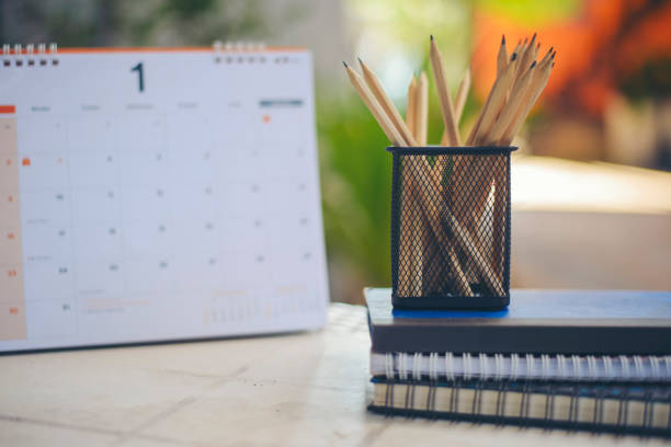 istock Desk for student education concept. Calendar, Pencils, book, note pad placed on School table for student work online and plan at home. 1440448783