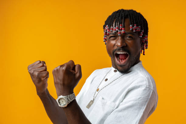 istock Young african man standing over yellow background doing winner gesture 1440448794