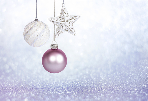 Christmas decorations on purple glitter background with copy space