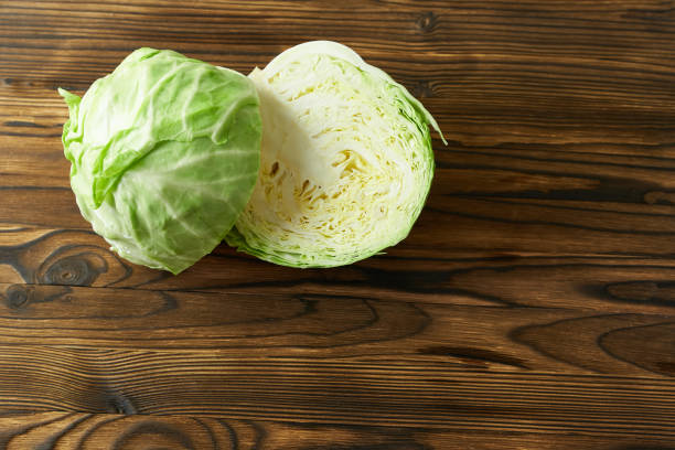 istock Cabbage cut in half on a wooden background, close-up. 1440450624