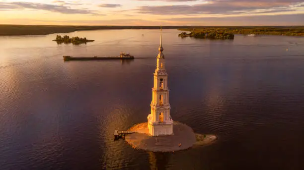 Beautiful view at sunset on Kalyazin Bell Tower in summer in Russia. Flooded Belfry in the middle of the river.