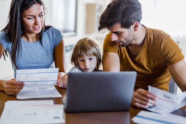 istock Young family paying bills over a computer at home. 1440451966