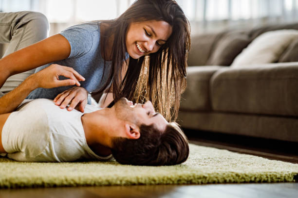 istock Happy couple having fun while talking in the living room. 1440452663