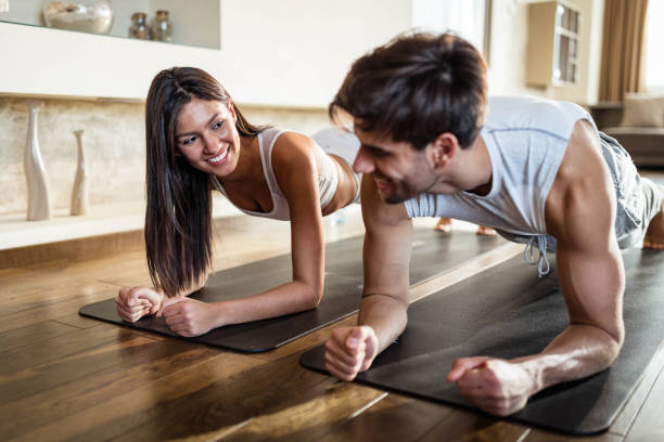 istock Happy athletic couple talking in a plank position at home. 1440452682