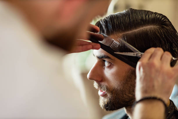 istock Young man having a haircut at barber shop. 1440452895