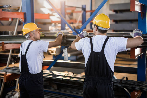 istock Manual workers cooperating while working with metal in aluminum mill. 1440453251