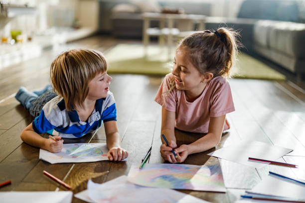 istock Happy little kids talking while drawing on floor at home. 1440454771