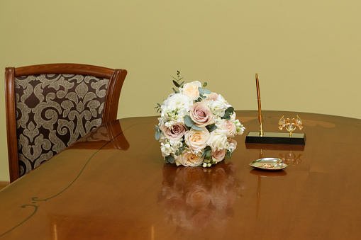 the bride's wedding bouquet is lying on the table next to the rings. the beginning of the wedding ceremony