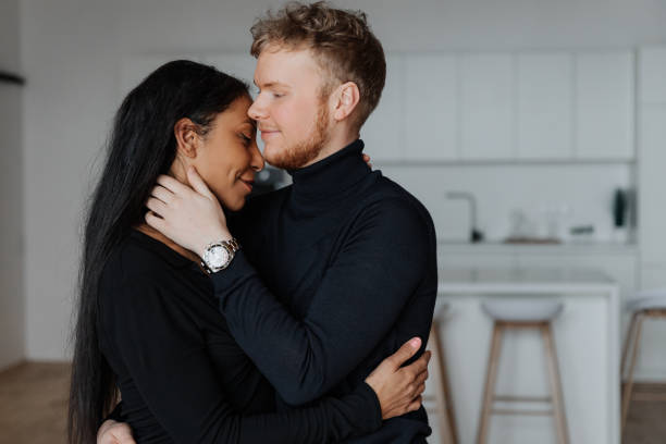 istock Young husband gently hugs his wife in the kitchen 1440455438
