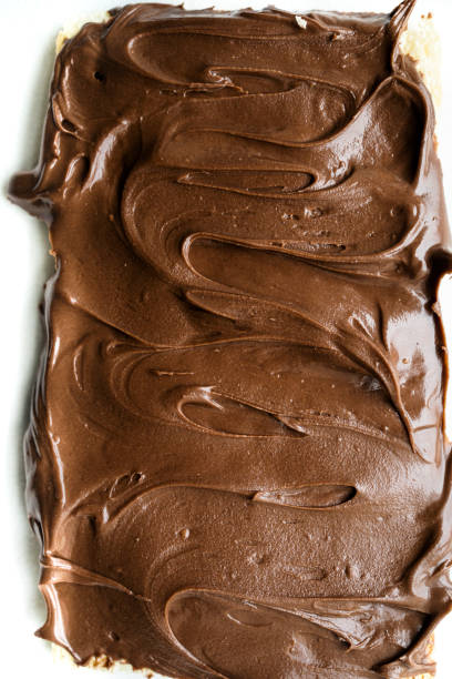 istock Bread toast with delicious chocolate cream. Chocolate cream texture with white background 1440456873