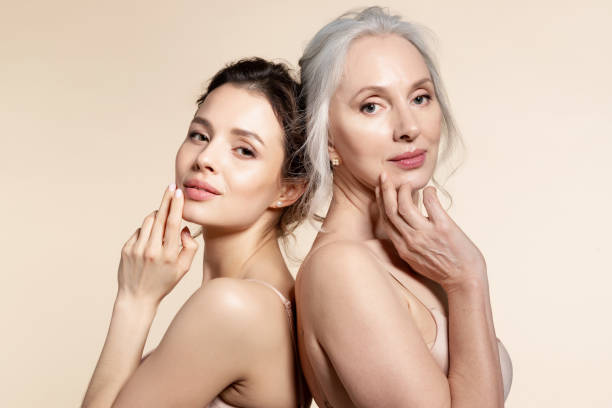 Portrait of senior and young woman Elderly and young women with smooth skin and natural makeup standing back-to-back. Thinking, planning, dreaming lingerie stock pictures, royalty-free photos & images