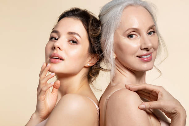 Different age beautiful woman portrait Two beautiful different age woman with perfect skin headshot portrait. Senior lady and young girl in underwear standing back-to-back posing for camera. Spa beauty salon procedure and home skincare attractive women stock pictures, royalty-free photos & images