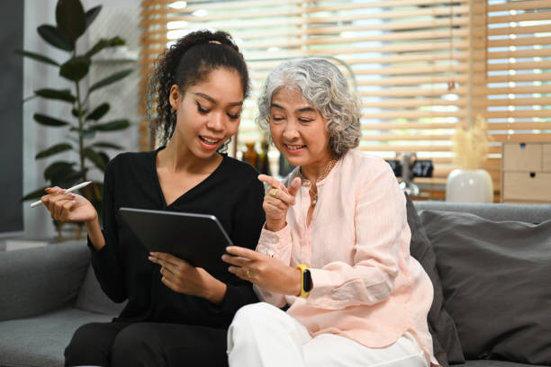 istock Smiling young woman teaching interested elderly mother how to use a tablet or shows some application. Elderly, technology concept. 1440460180