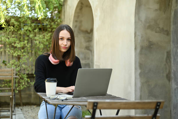 istock Attractive female freelancer working online on laptop while sitting outdoor. 1440460549
