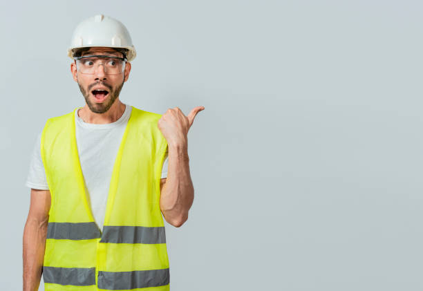 istock Surprised engineer pointing to the side. Surprised face construction worker pointing at an advertisement. Engineer man pointing to side. Surprised face engineer pointing finger to the right 1440462591