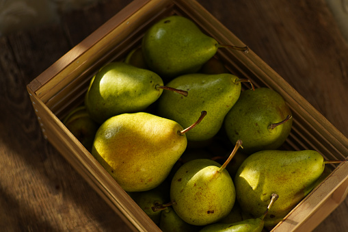 Pears on a wooden background. Fruit harvest. Autumn still life. Pear variety Bera Conference.