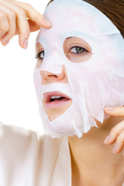 istock Woman applying sheet mask on face 1440463165
