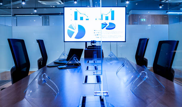 istock Presentation slide show on display television with clear acrylic sheet separatescenter on  table to prevent COVID-19 and face shield 1440463281