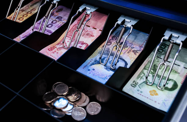 istock Thai bank notes and coins are in cashier machine 1440464533