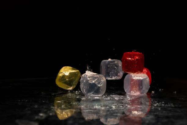 istock Falling colored cubes splashed with water on a black background. Red, yellow, blue and transparent. Conceptual, celebrated, commercial design 1440464650