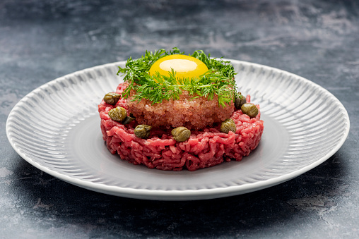 High angle view of steak tartare served with lumpfish caviar, capers, and the obligatory raw egg yolk. Known as “stenbidderogn” in Denmark it is only available in early spring, a real luxury experience.