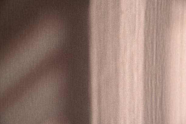istock Diagonal and vertical shady stripes on light wall macro view 1440466413