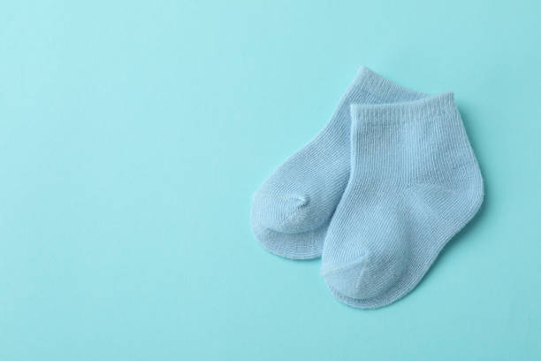 istock Pair of cute baby socks on blue background 1440468630