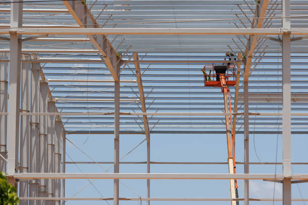 istock Aerial work platforms of cherry picker in the factory site construction. cherry picker machine for worker installation of steel structure roof work . 1440469322