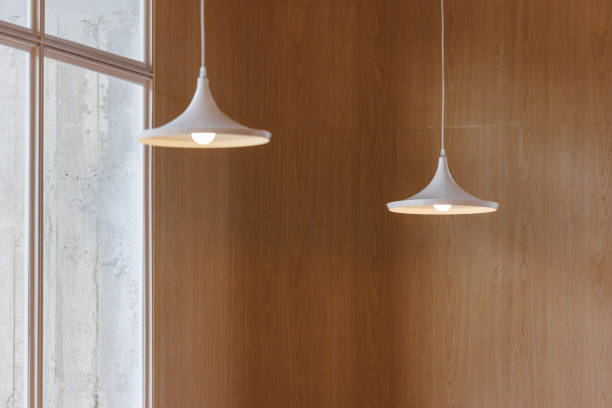 istock white hanging steel lamp on wooden wall background. 1440469393