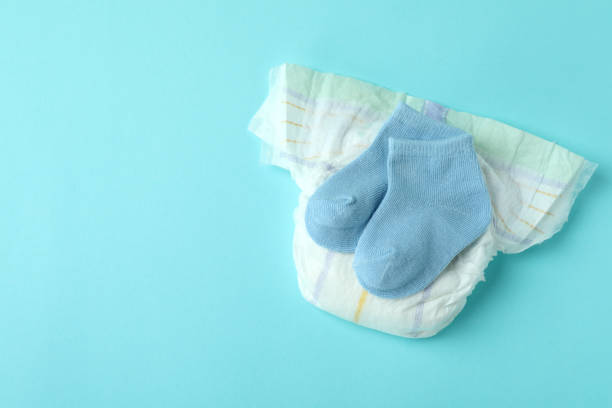 istock Diaper with baby socks on blue background 1440469417