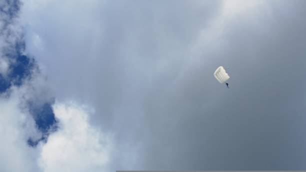 le pilote s’est éjecté de l’avion explosé et est descendu au sol en parachute. adrénaline dans le sang d’un parachutiste volant dans le ciel avec un parachute de type aile ouverte. - flying air vehicle performance airshow photos et images de collection