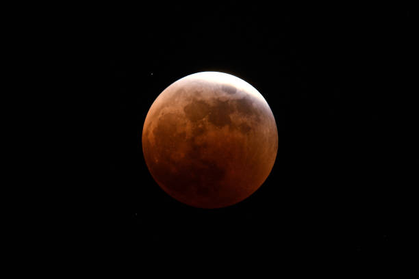 istock The moon in a total lunar eclipse, almost in the shadow of the earth. 1440471854