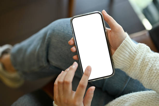 istock A female using her smartphone while sitting in the coffee shop. smartphone white screen mockup. 1440472525