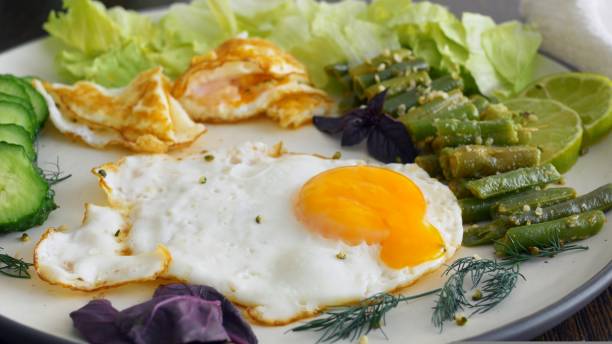 istock Healthy breakfast scrambled eggs green vegetables eaten with fork fill with energy whole day. Proper nutrition for health. Delicious breakfast with saturated fat proteins and fiber for balanced diet 1440473043