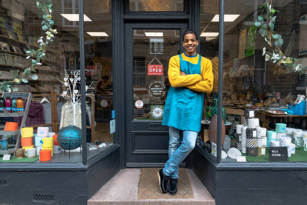 male business owner standing in front of store - detailhandel beroep fotos stockfoto's en -beelden