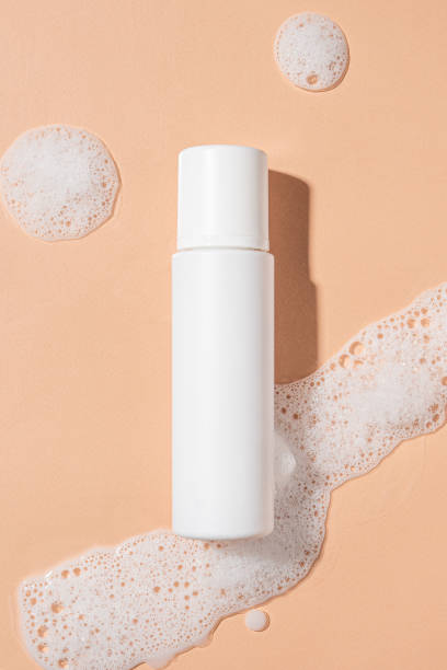 istock Packaging for cosmetics bottles without logo and label on beige background with foam. Mockup cosmetics 1440475265
