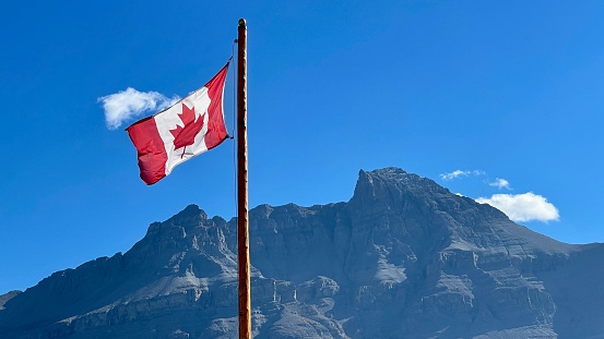 Canadian flag Waving against blue sky in a sunny day, Canada