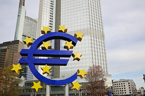 Euro sign in front of European Central Bank headquarters skyscrapers in Frankfurt am Main financial district, Euro currency sign