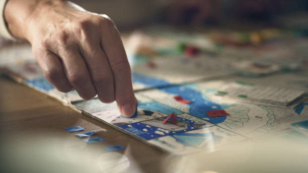 istock Human hand moving the pieces on a game board 1440476421