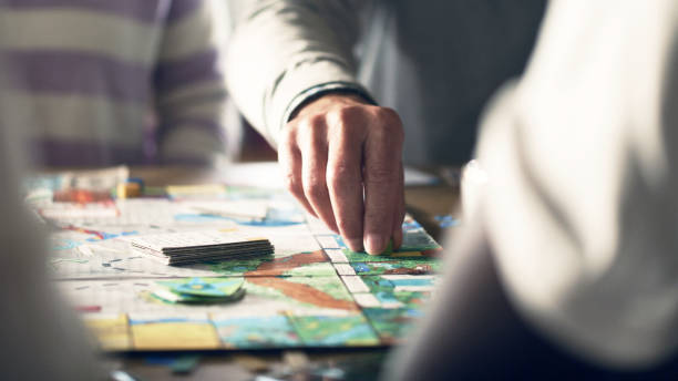 Elderly male human hand moving the pieces on a game board stock photo