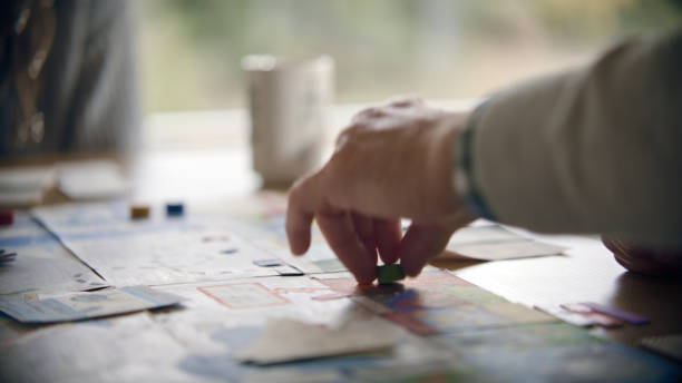 istock Human hand moving the pieces on a game board. Playing board game together 1440476435