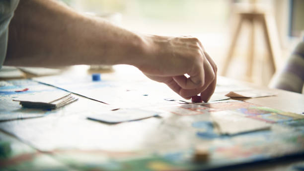istock Male human hand moving the pieces on a game board. Playing board game together 1440476445