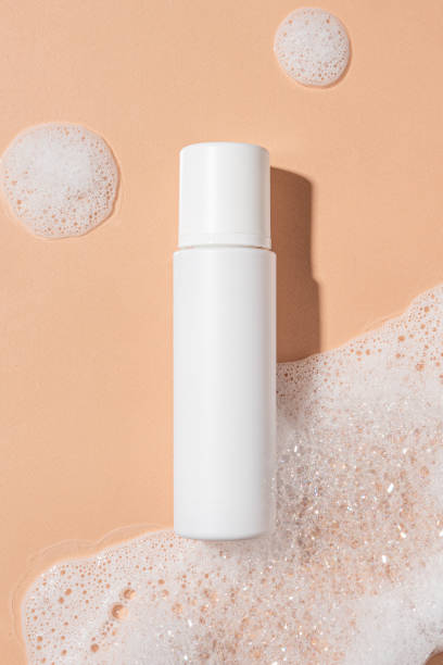 istock Packaging for cosmetics bottles without logo and label on beige background with foam. Mockup cosmetics 1440476547