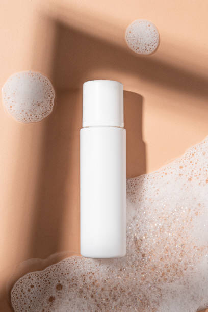 istock Packaging for cosmetics bottles without logo and label on beige background with foam. Mockup cosmetics 1440476616
