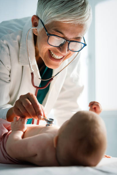 istock Happy pediatrician doctor with baby checking possible heart defect 1440476623