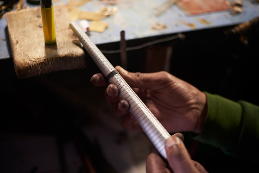 Jewelry, craft and manufacturing with a man artisan measuring a ring size while working in his workshop. Design, creative and industry with jewellery in the hands of a male designer in his studio
