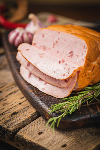 istock Spicy smoked ham with rosemary and kitchen knife on a table 1440479015