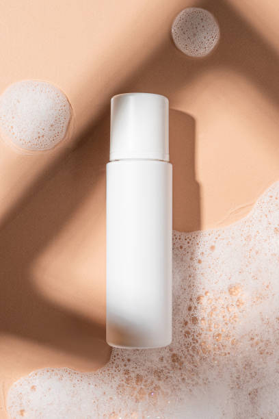 istock Packaging for cosmetics bottles without logo and label on beige background with foam. Mockup cosmetics 1440479151