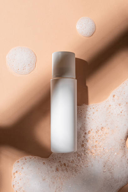 istock Packaging for cosmetics bottles without logo and label on beige background with foam 1440479334
